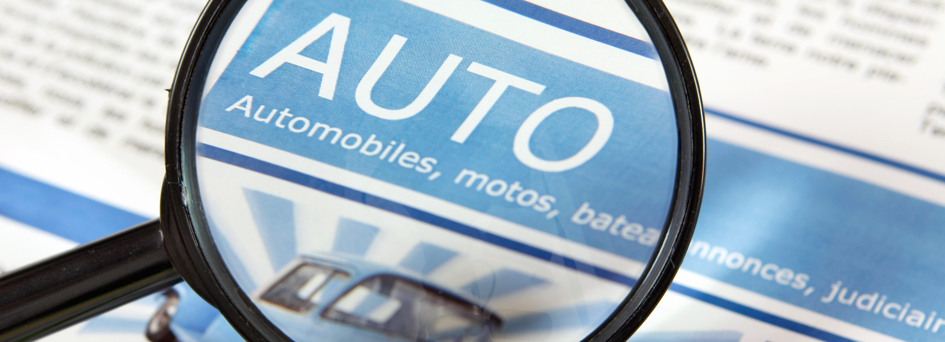 photo d'un titre de journal d'annonces automobiles observé à la loupe
