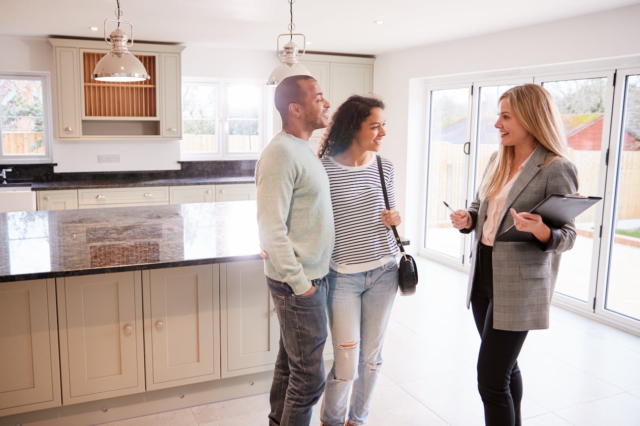 Une agent immobilier fait visiter un bien à un couple 